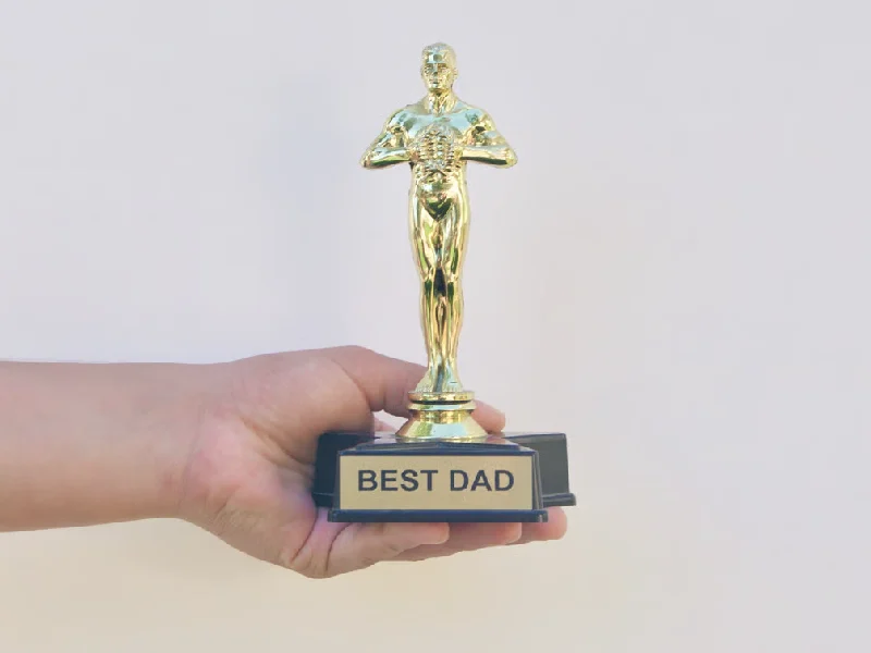 Hand Holding a 'Best Dad' Trophy